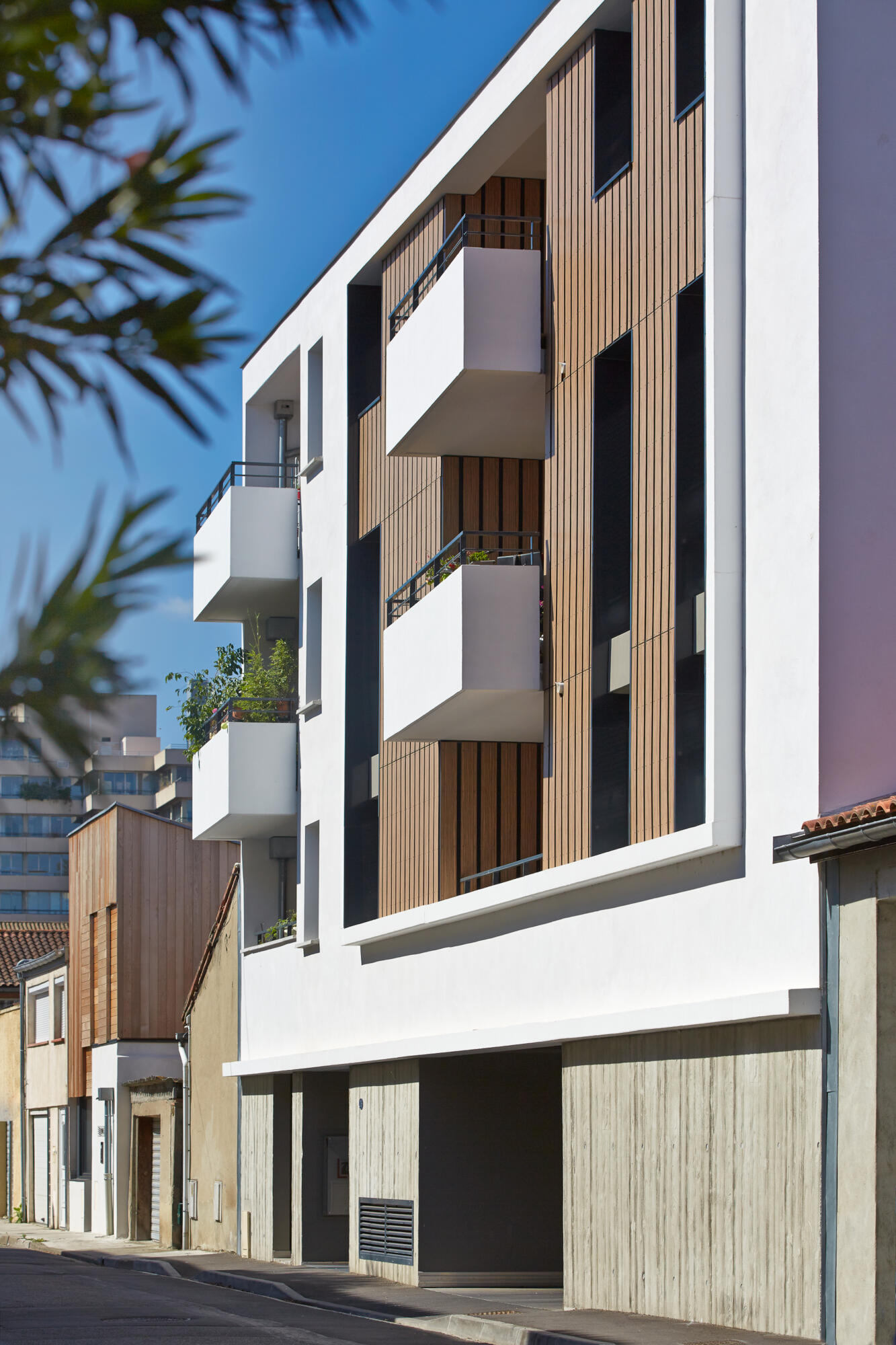 Photographie d'une façade d'immeuble résidentiel moderne avec balcons et bardage bois. Par Studio ZE, photographe d'architecture à Toulouse.