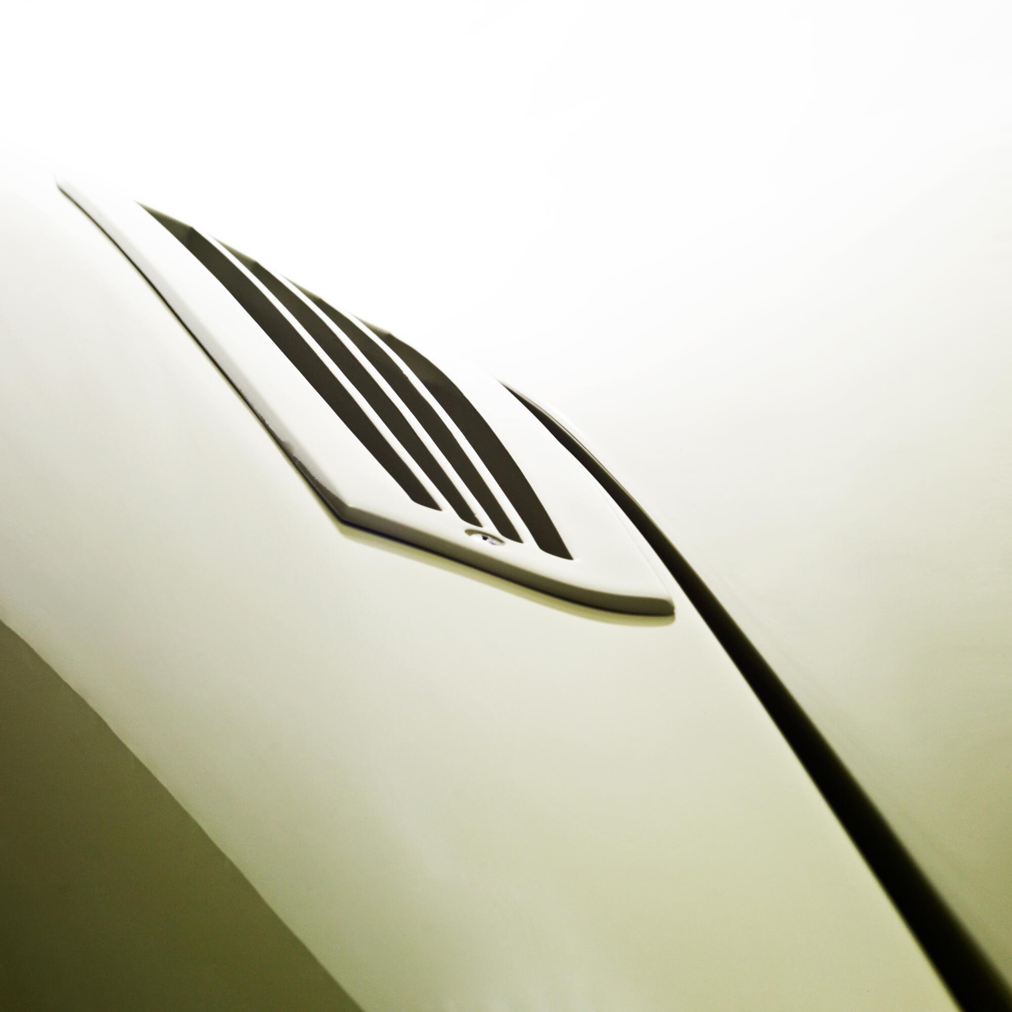 Photographie professionnelle en gros plan d'un détail de design automobile, mettant en valeur une grille d'aération noire sur une carrosserie élégante. Image réalisée par Studio ZE, photographe d'objet industriel et automobile à Toulouse.