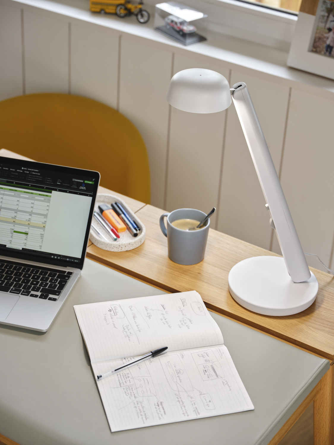 Photographie d'une lampe de bureau blanche au design moderne, mise en scène dans un décor de bureau contemporain. Image réalisée par Studio ZE, photographe d'objet et d'ambiance à Toulouse.