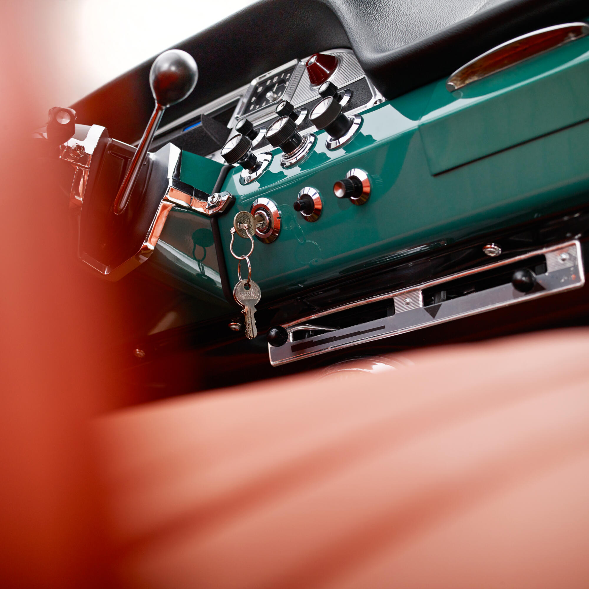 Photographie en gros plan du tableau de bord vert d'une voiture ancienne, avec les clefs sur le contact. Par Studio ZE, photographe automobile à Toulouse.