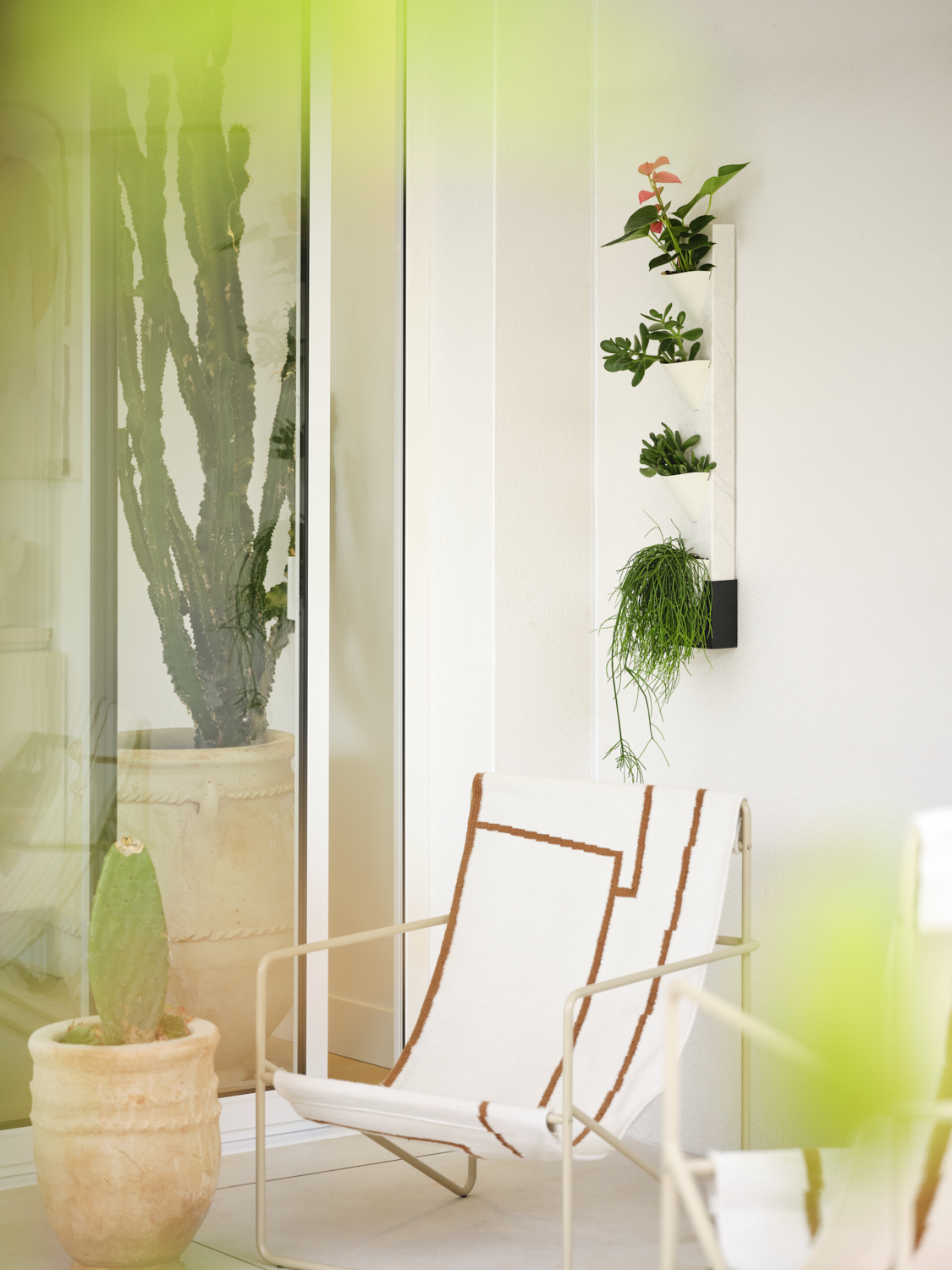 Photographie d'une tour végétale murale blanche et design avec différentes plantes vertes, intégrée dans un décor intérieur. Image réalisée par Studio ZE, photographe d'objet et de décoration à Toulouse.