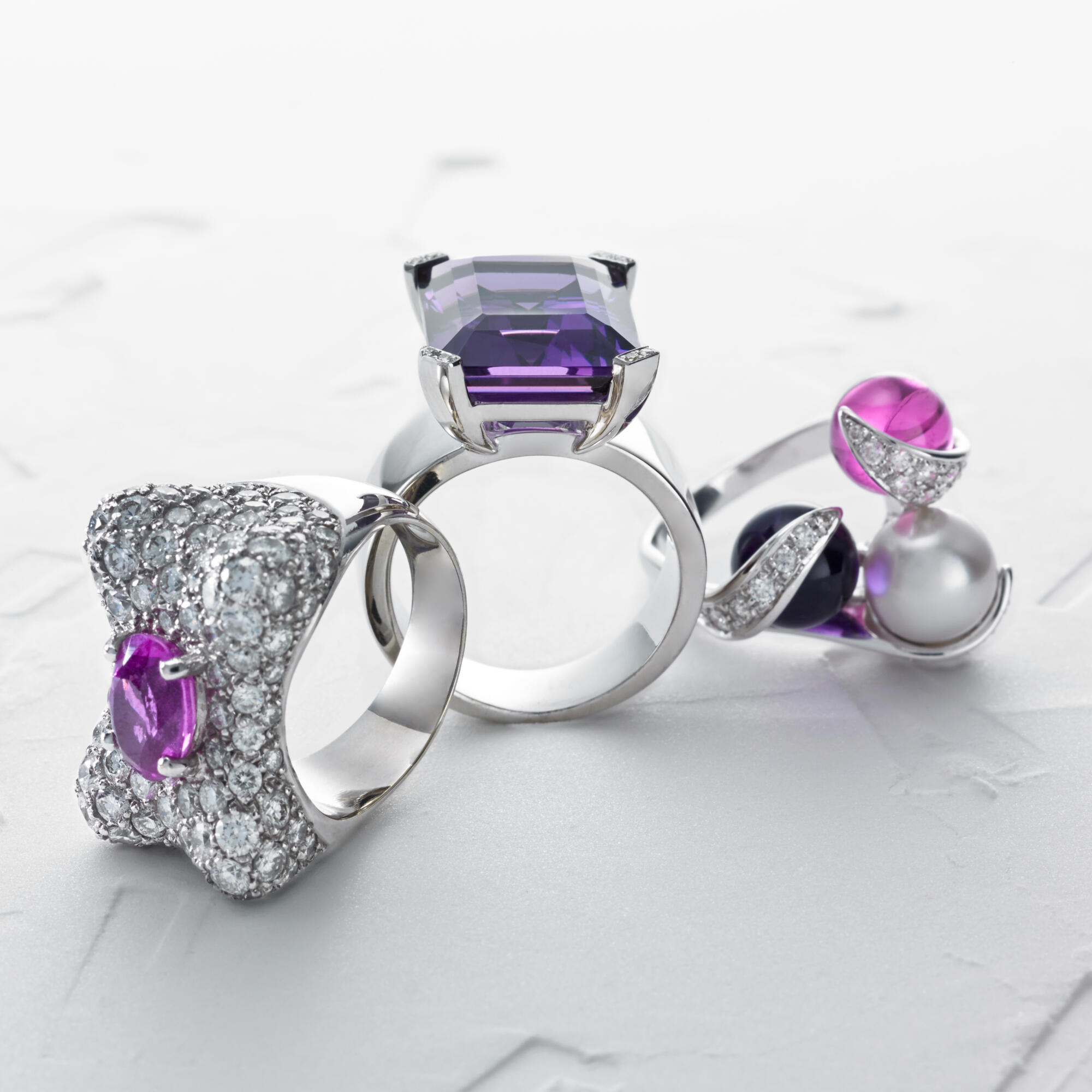 Photographie de bagues de luxe en or blanc avec diamants, améthystes et tourmalines roses. Par Studio ZE, photographe bijoux à Toulouse.