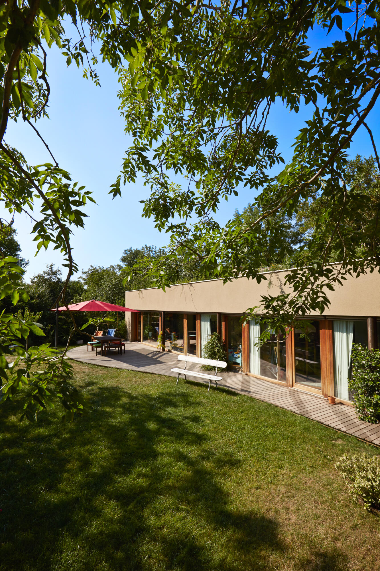 Photographie d'une maison moderne avec grand jardin et terrasse. Par Studio ZE, photographe d'architecture et villas à Toulouse.