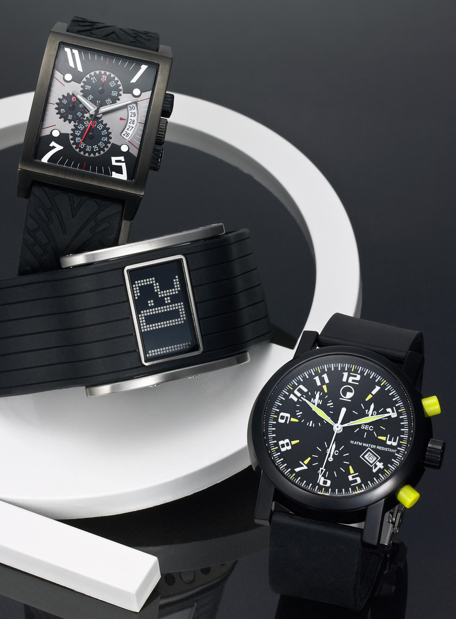 Photographie de trois montres homme modernes : chronographe carré, digitale, et sport cadran noir. Par Studio ZE, photographe bijoux à Toulouse.