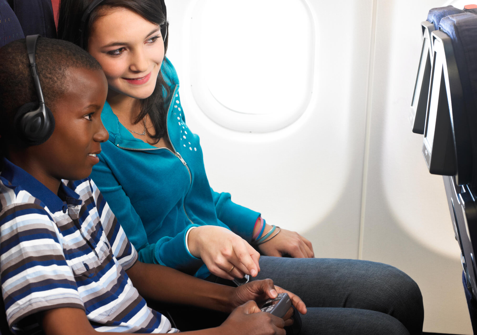 Photographie de deux passagers dans un avion, une femme et un homme regardant un écran avec une télécommande à la main. Par Studio ZE, photographe humain à Toulouse.
