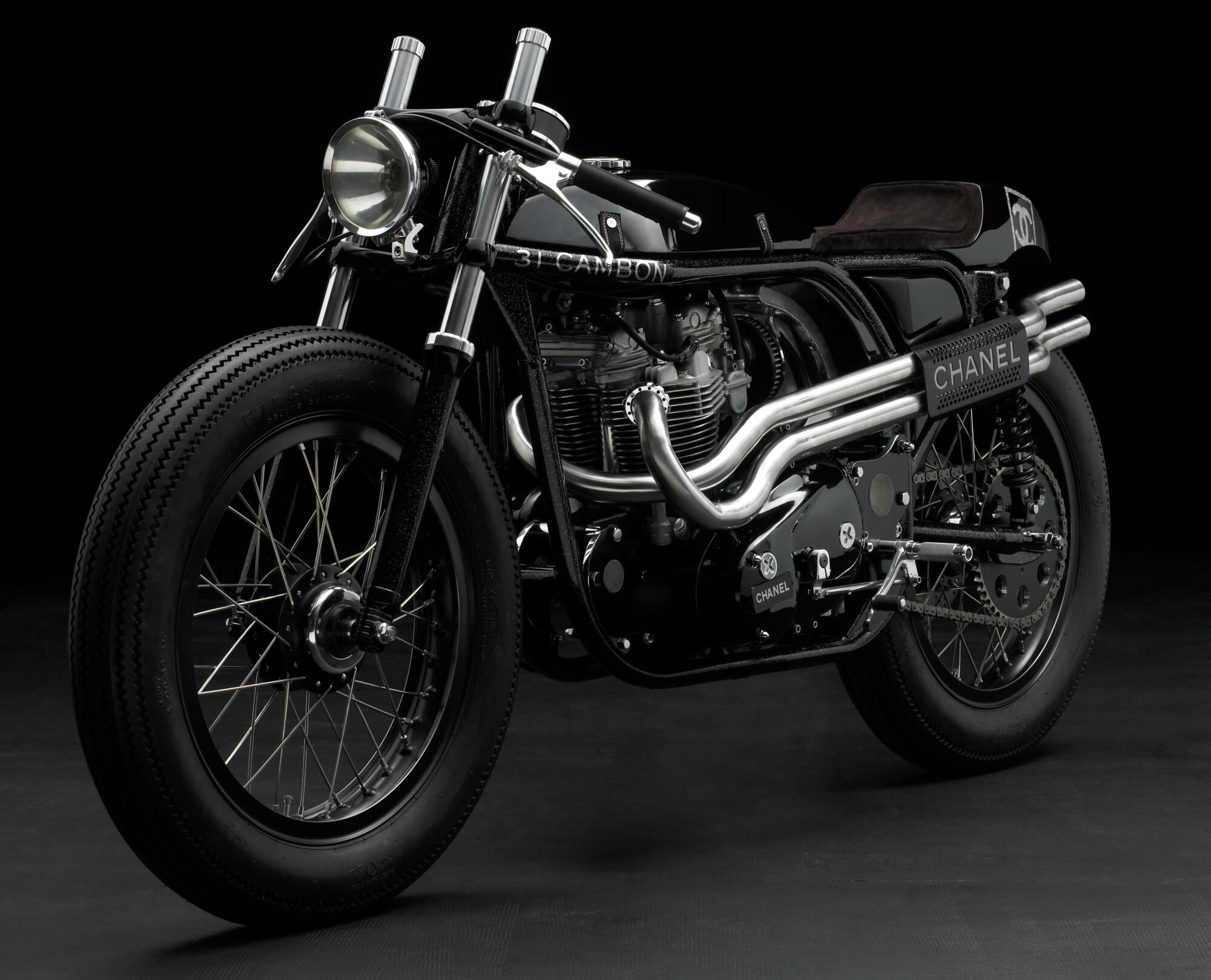 Photographie d'une moto customisée noire brillante avec des éléments chromés et des inscriptions 'CHANEL' et '31 CAMBON', sur fond sombre. Par Studio ZE, photographe auto moto à Toulouse.