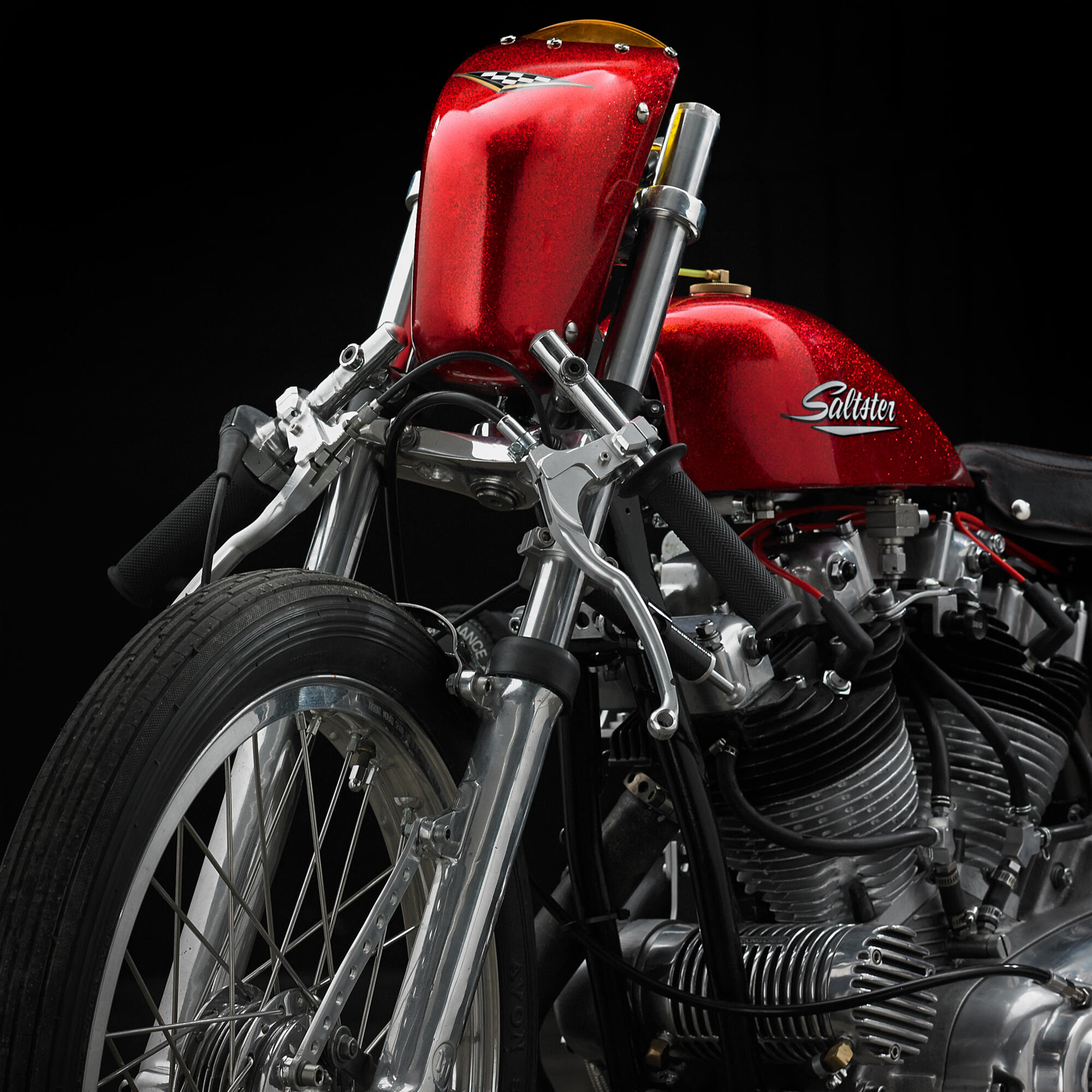 Photographie d'une moto de course vintage rouge brillante avec le nom 'Saltster' sur le réservoir, sur fond noir. Par Studio ZE, photographe auto moto à Toulouse.