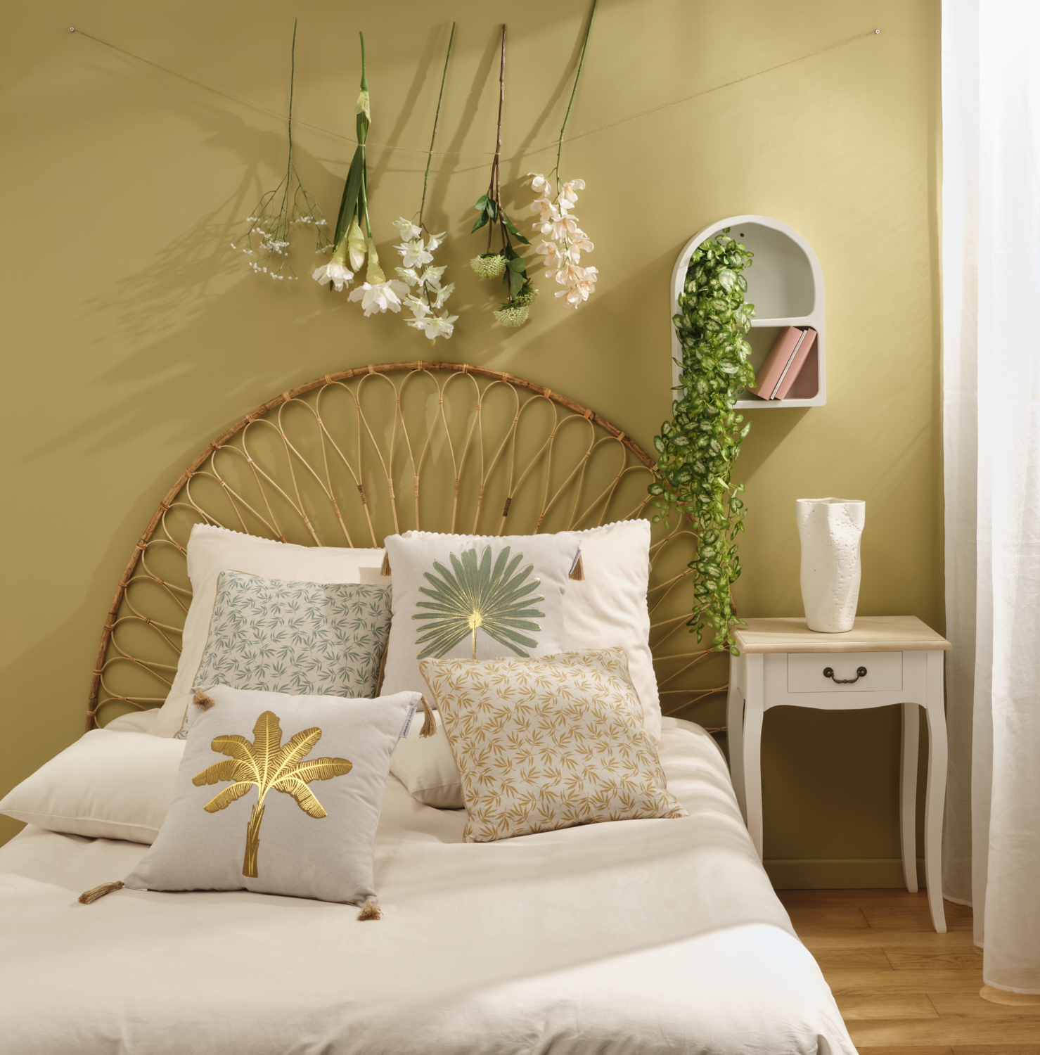 Photographie d'une chambre moderne avec tête de lit en rotin, coussins à motifs et plantes suspendues. Par Studio ZE, photographe d'intérieur à Toulouse.