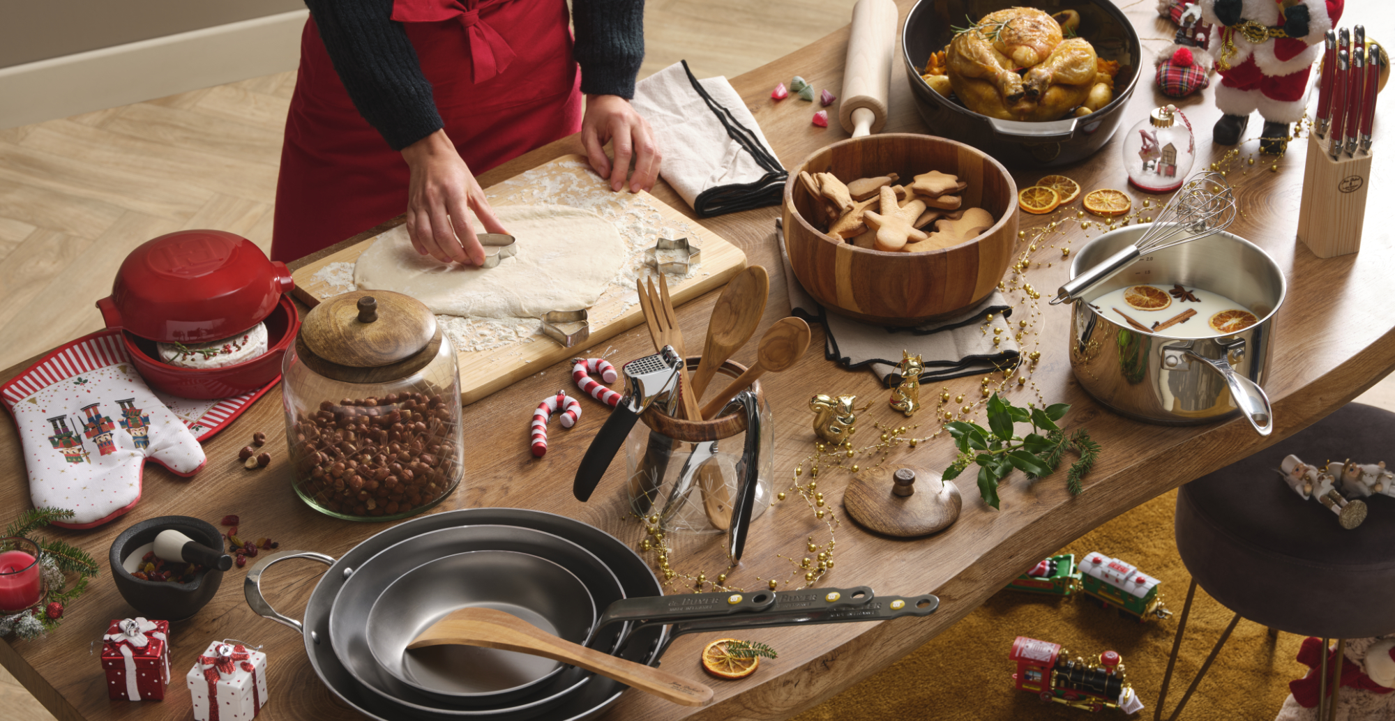Photographie de cuisine de Noël avec préparation de biscuits, poulet rôti, et ustensiles, ambiance festive. Par Studio ZE, photographe culinaire à Toulouse.