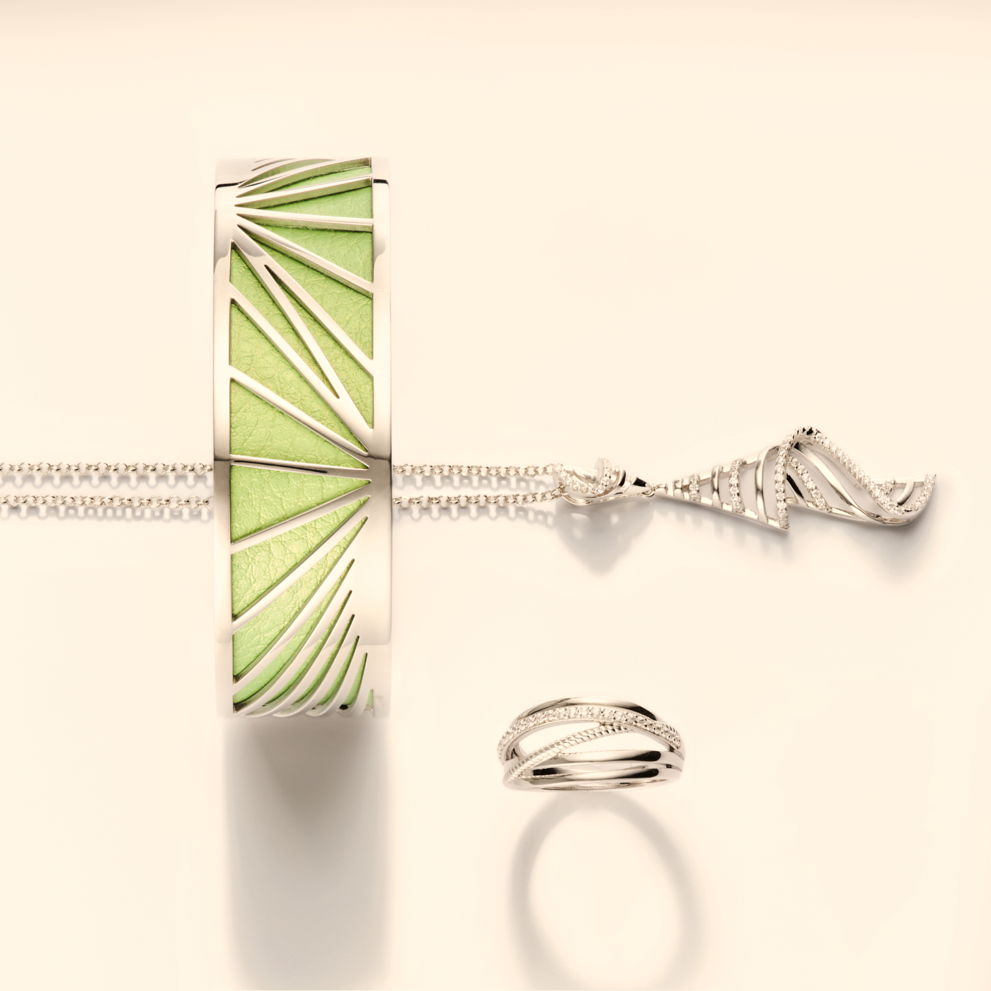 Photographie d'un ensemble de bijoux en argent et diamants, avec un bracelet manchette vert, un collier et une bague. Par Studio ZE, photographe bijoux à Toulouse.