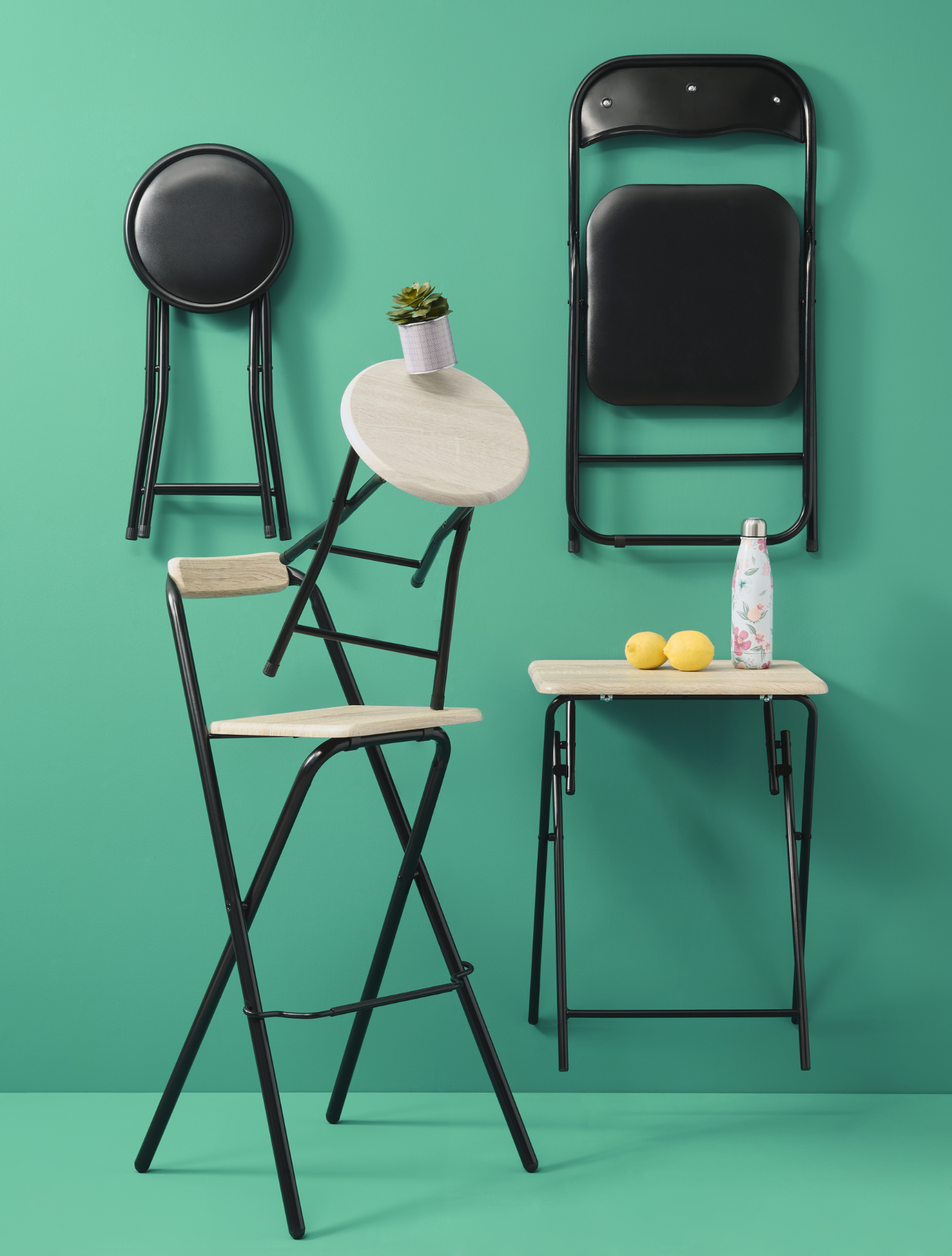Photographie professionnelle de chaises et tabourets pliants variés, certains en équilibre, sur fond vert. Image réalisée par Studio ZE, photographe d'objet et mobilier design à Toulouse.