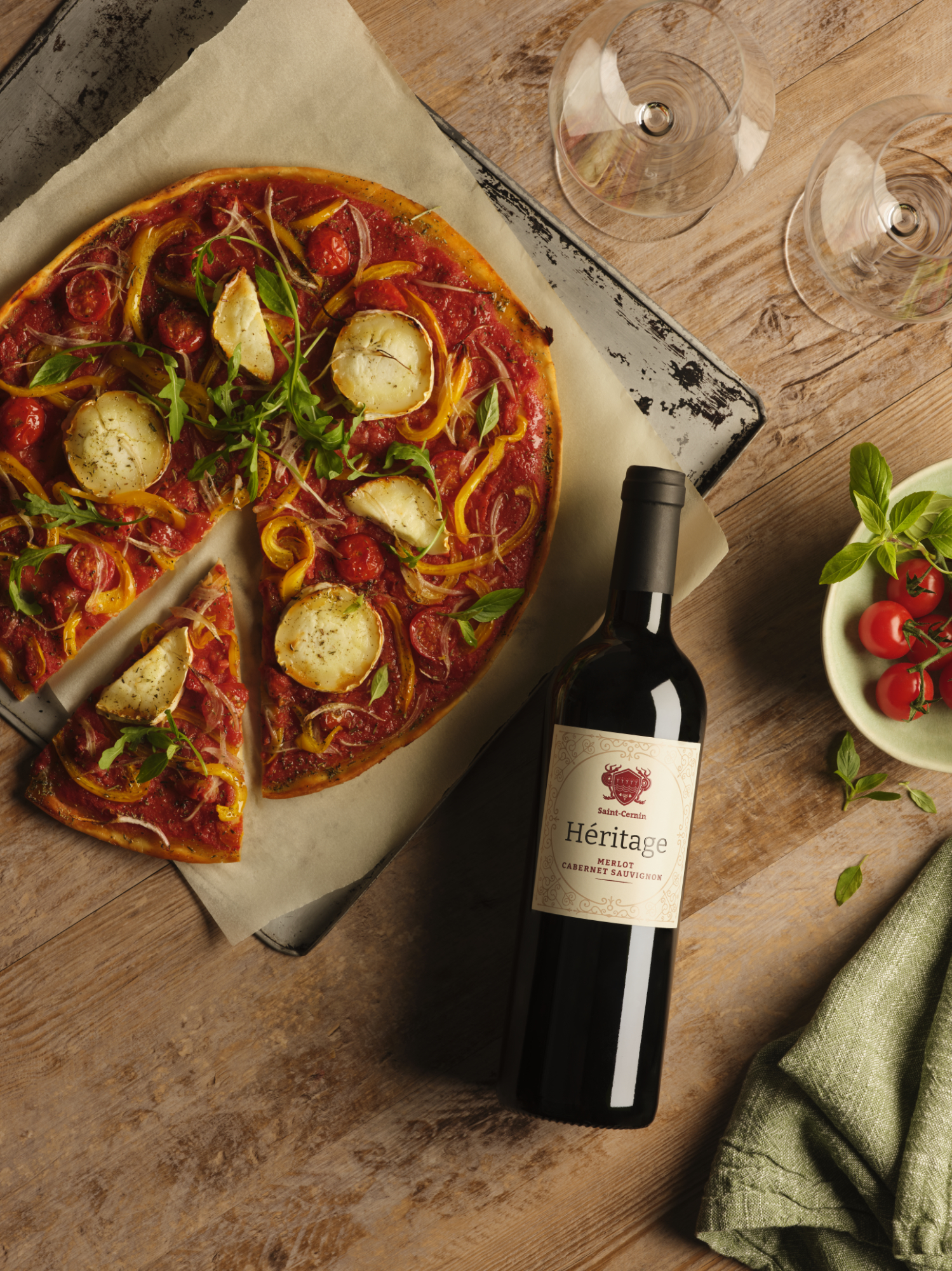 Photographie d'une bouteille de vin rouge Héritage, accompagnée d'une pizza au chèvre. Par Studio ZE, photographe de vin à Toulouse.